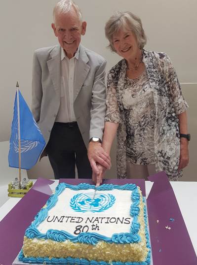 A person and person standing next to a cake  AI-generated content may be incorrect.